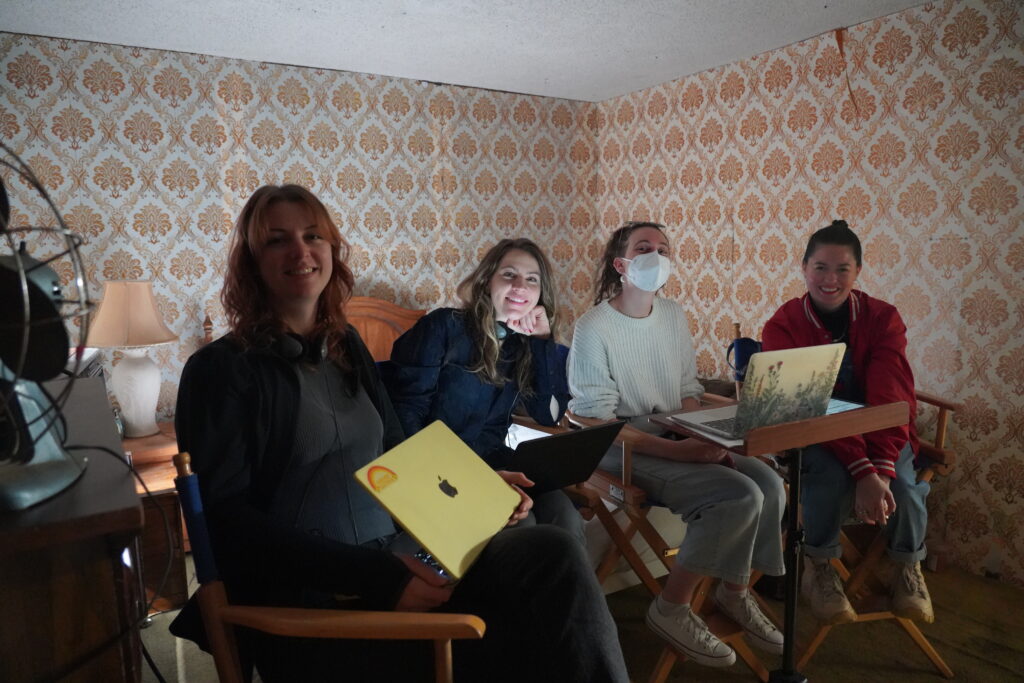 The four members of the crew of "Concrete" on set and smiling at the camera.