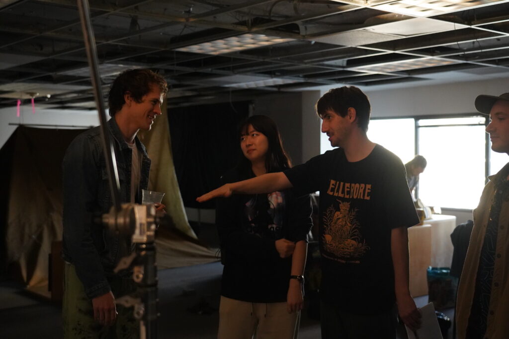 Four cast and crew members of the film "Concrete" talking while one points to the side.